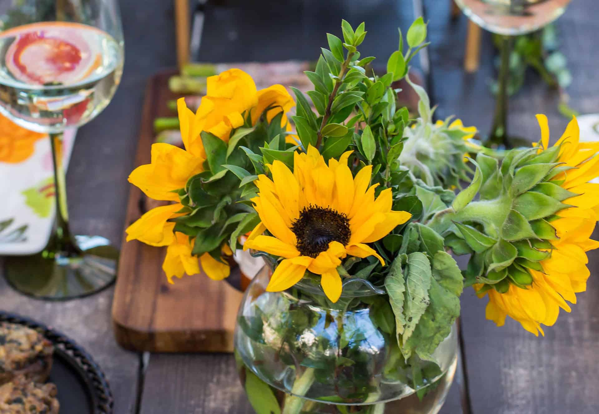 Sunflower bouquet with greenery in a glass vase, perfect for enhancing a personal chef event ambianc.